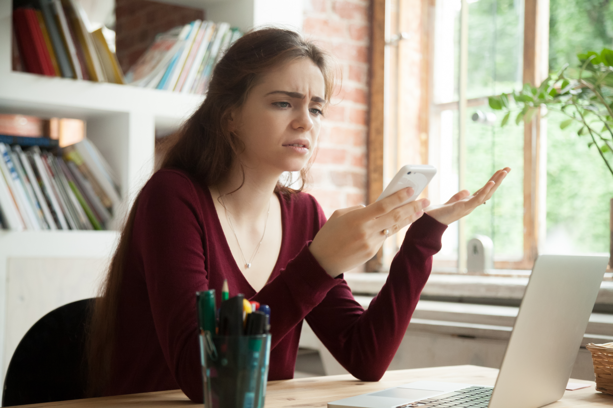 Confused woman looking at phone